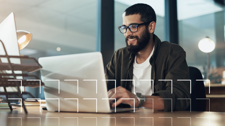 A man in glasses working at a laptop
